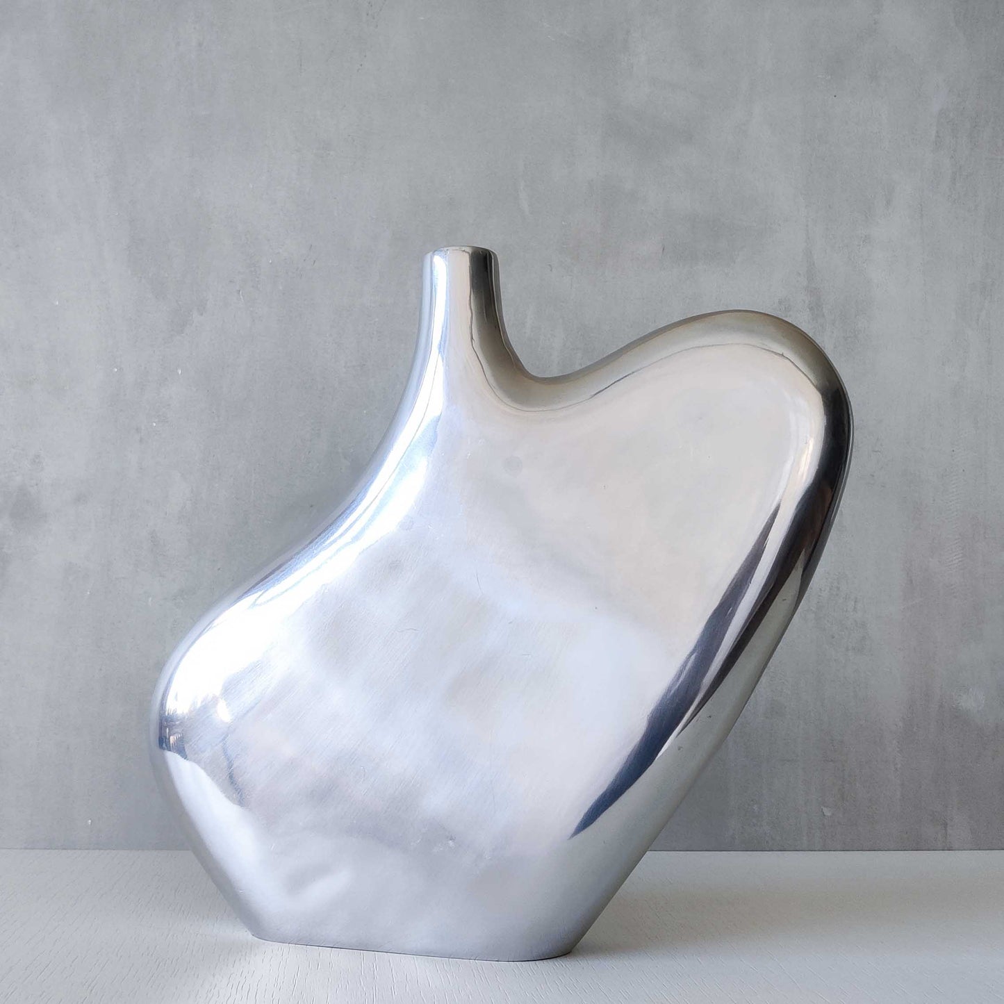 A large cast aluminium sculptural asymmetric vase