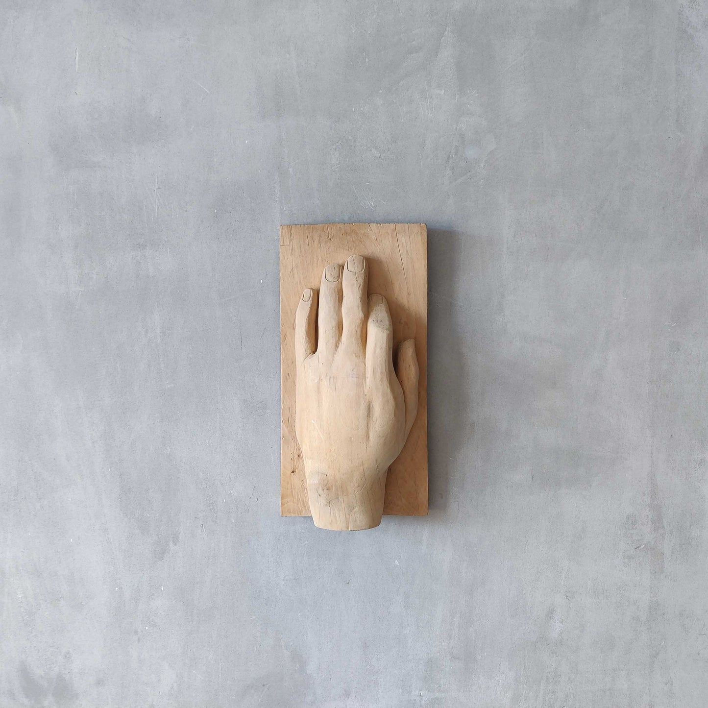 A carved tulip wood hand wall relief sculpture