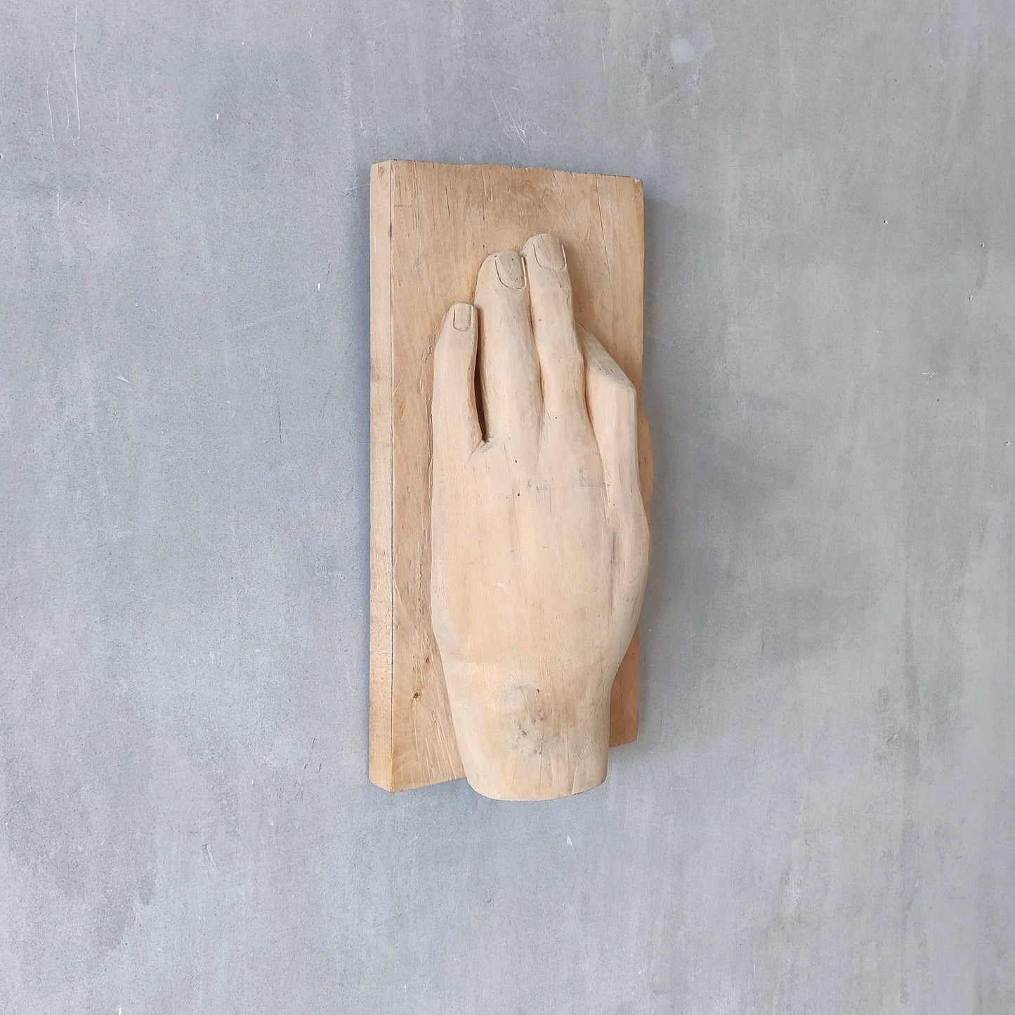 A carved tulip wood hand wall relief sculpture