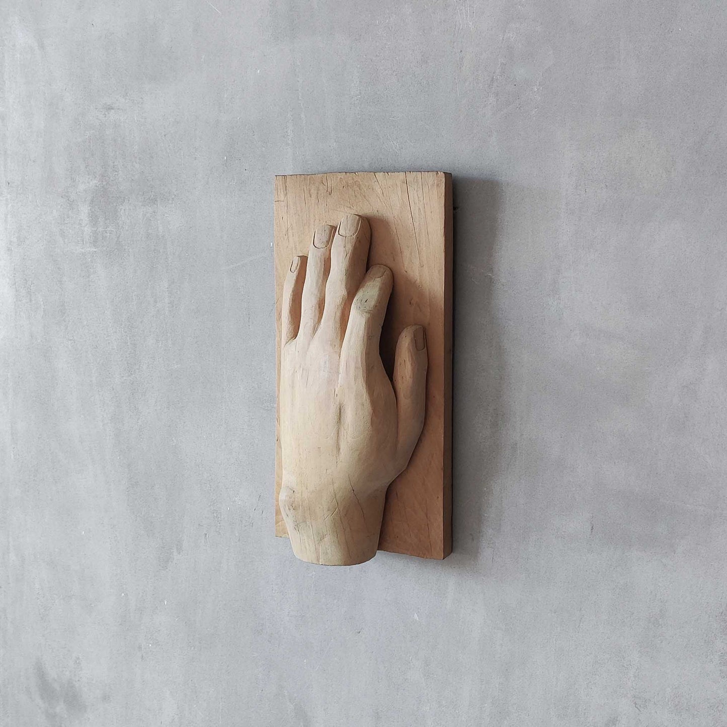 A carved tulip wood hand wall relief sculpture