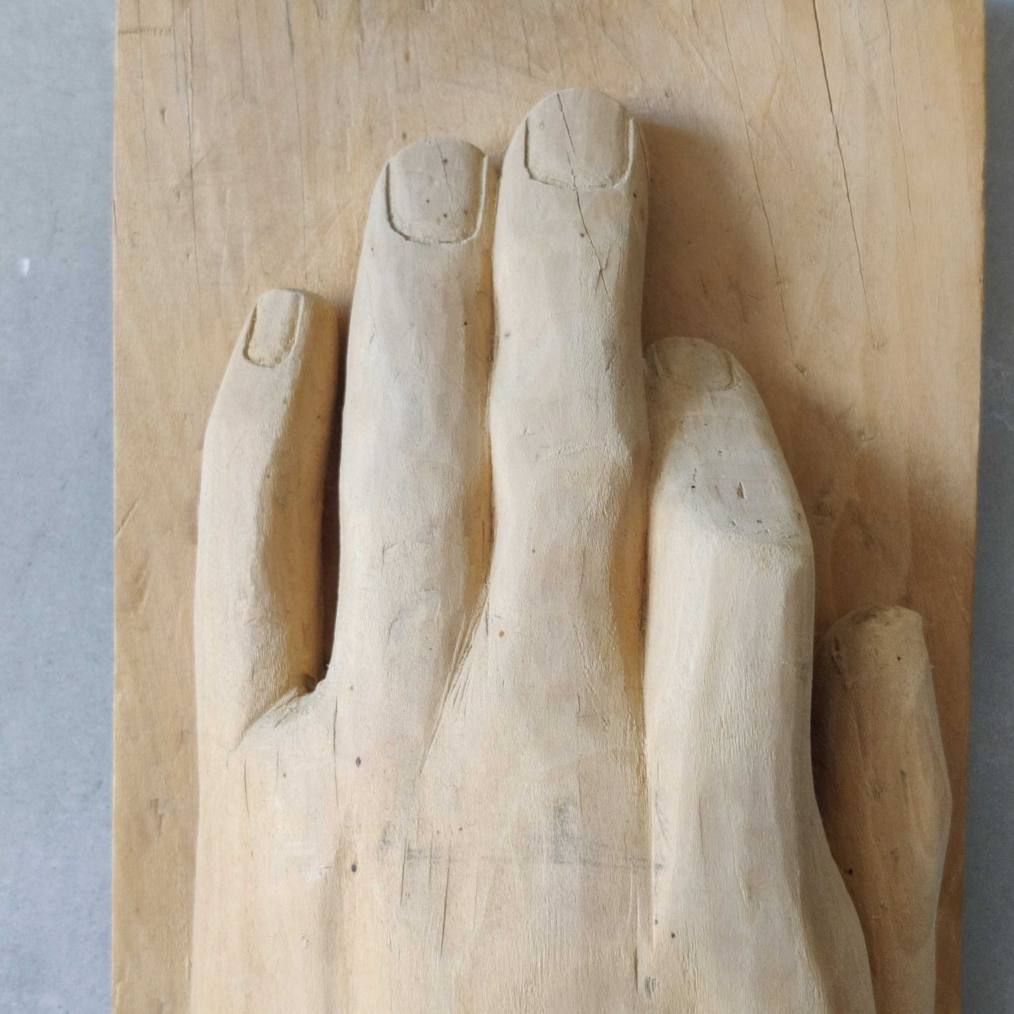 A carved tulip wood hand wall relief sculpture