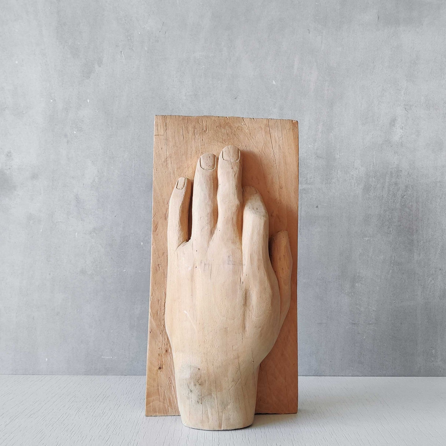 A carved tulip wood hand wall relief sculpture