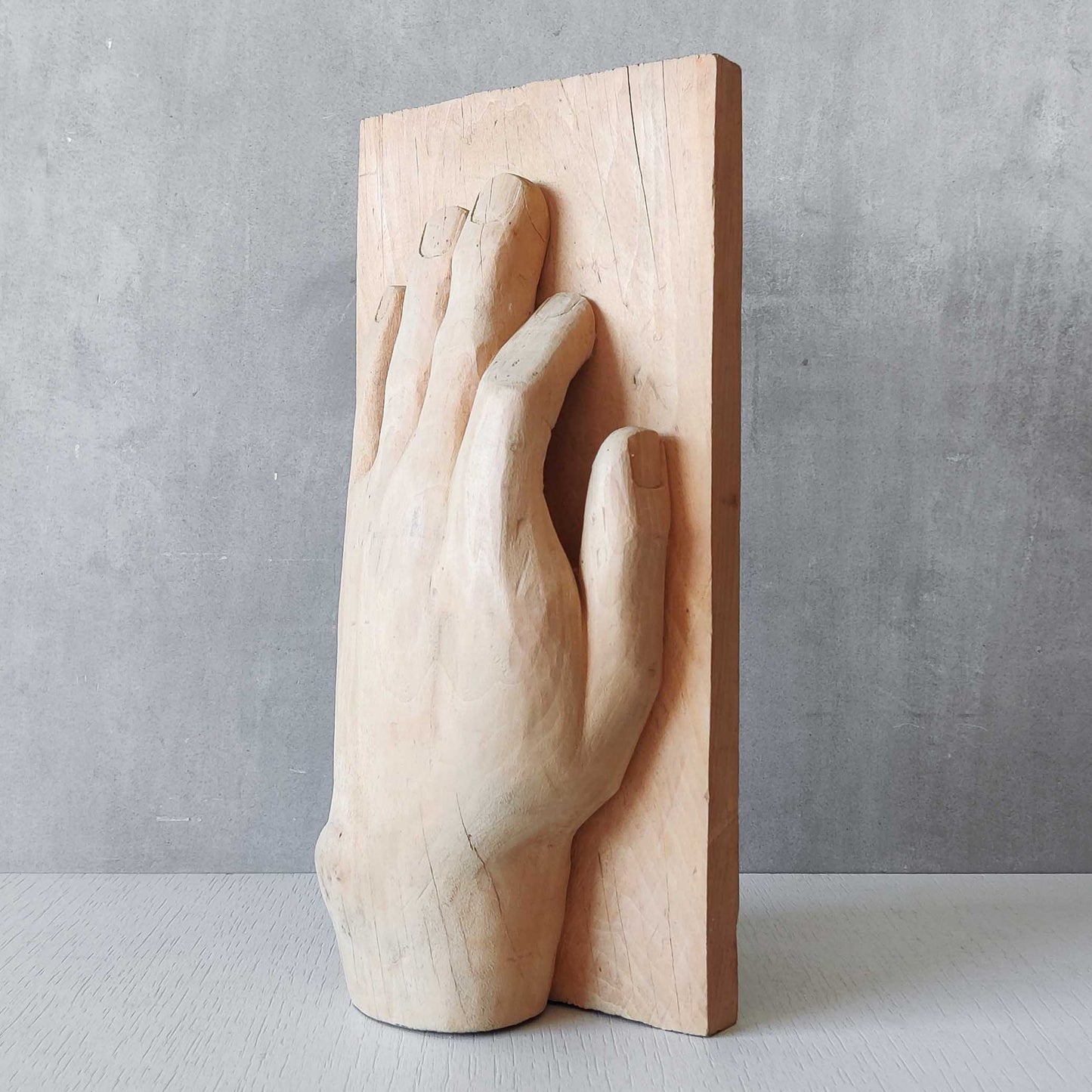 A carved tulip wood hand wall relief sculpture