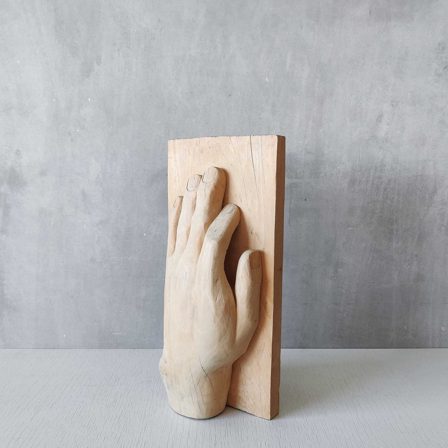 A carved tulip wood hand wall relief sculpture