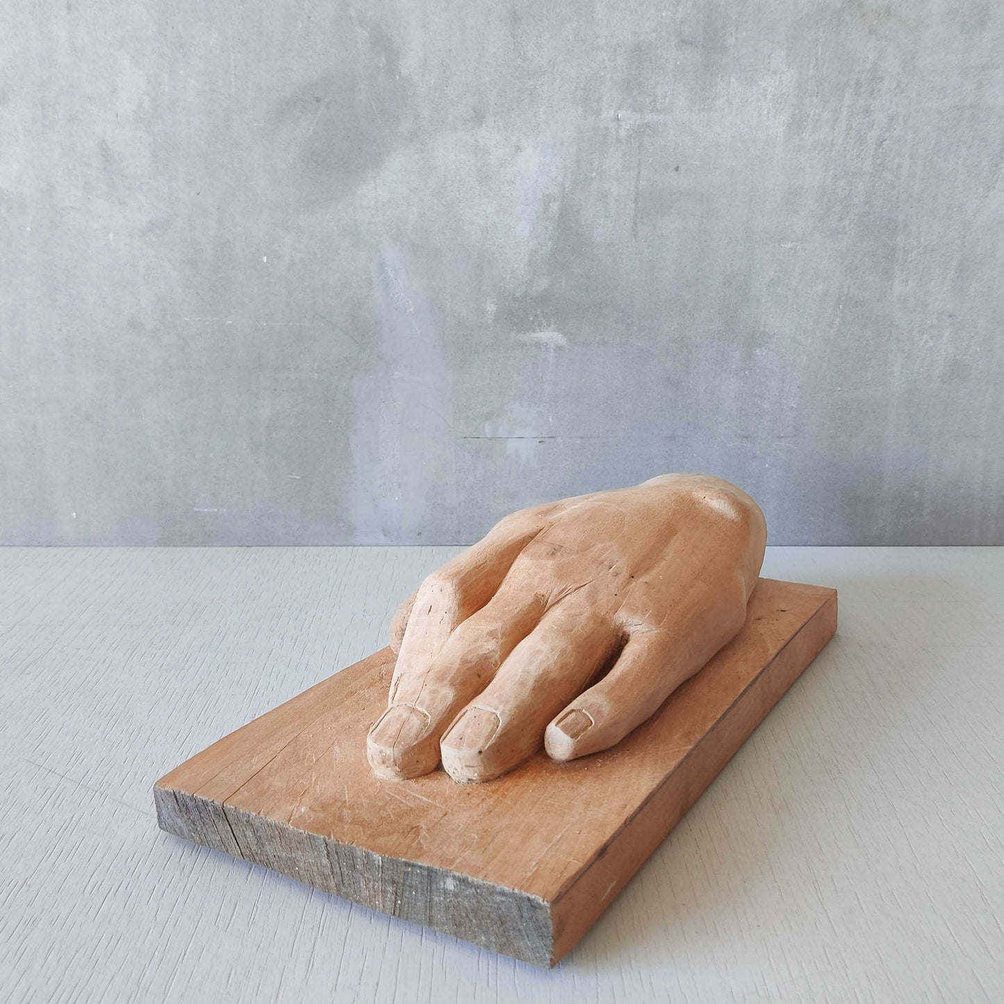 A carved tulip wood hand wall relief sculpture