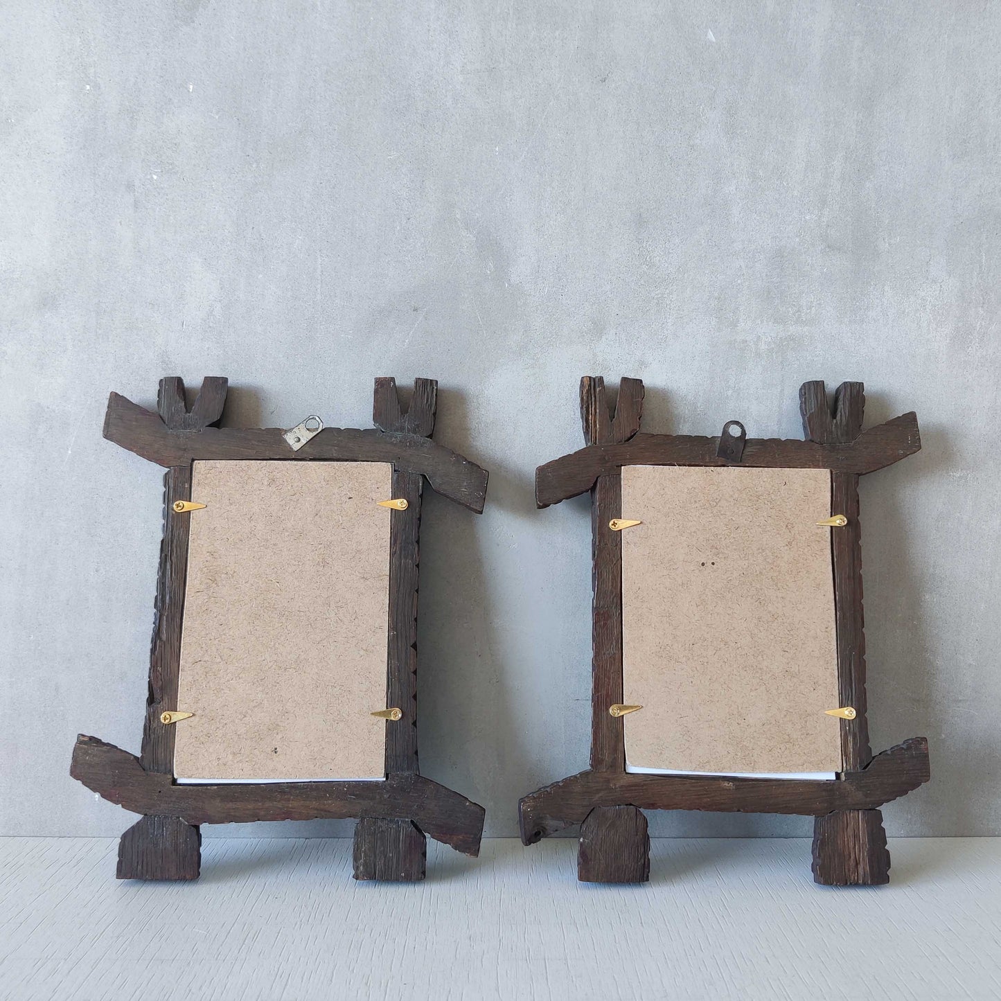 A pair of sculptural tramp folk art notched hand carved oak cross corner frames