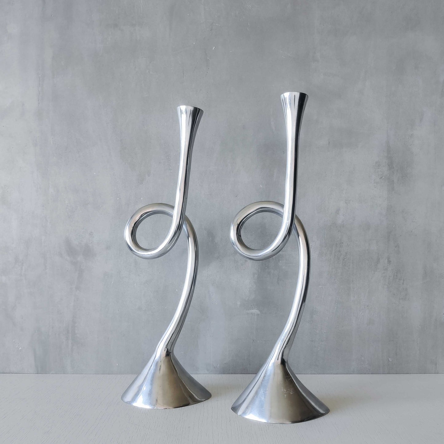 A pair of large vintage cast aluminium knotted loop candle holders