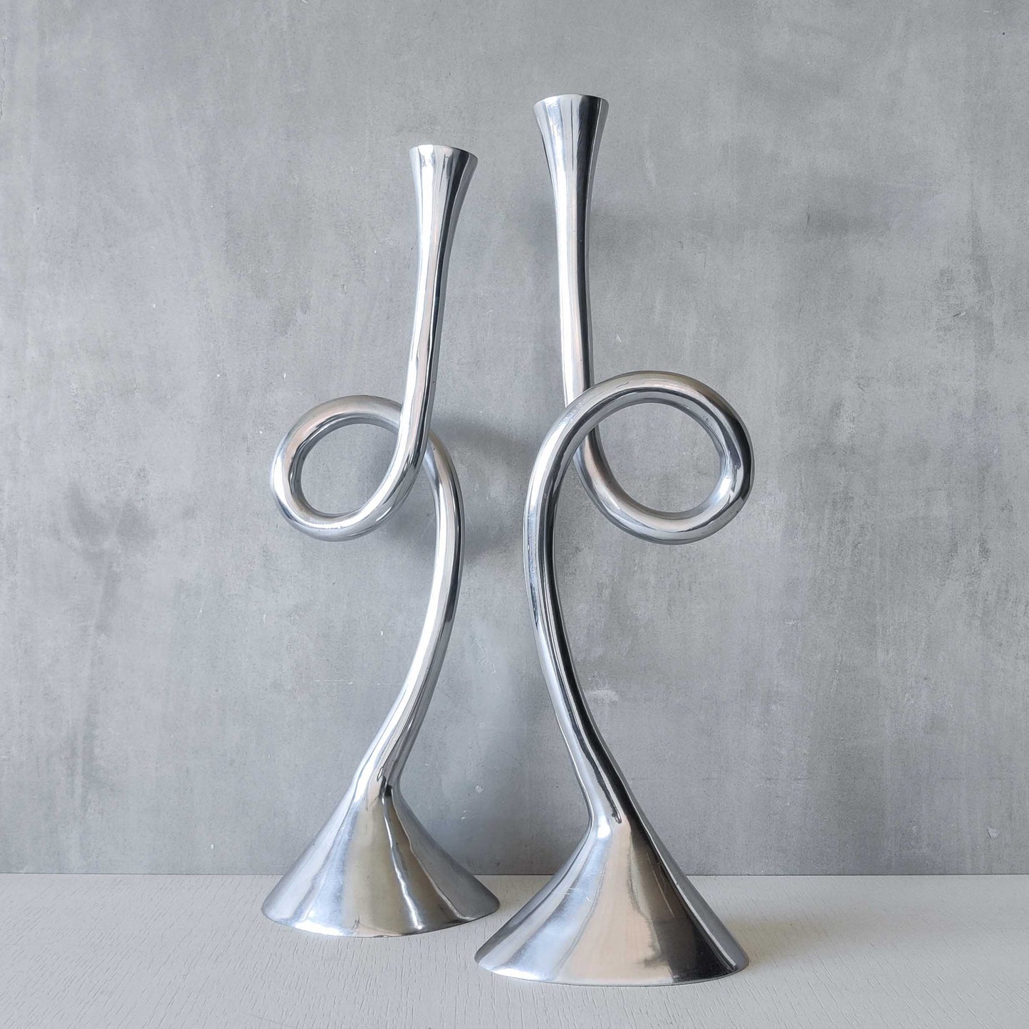 A pair of large vintage cast aluminium knotted loop candle holders