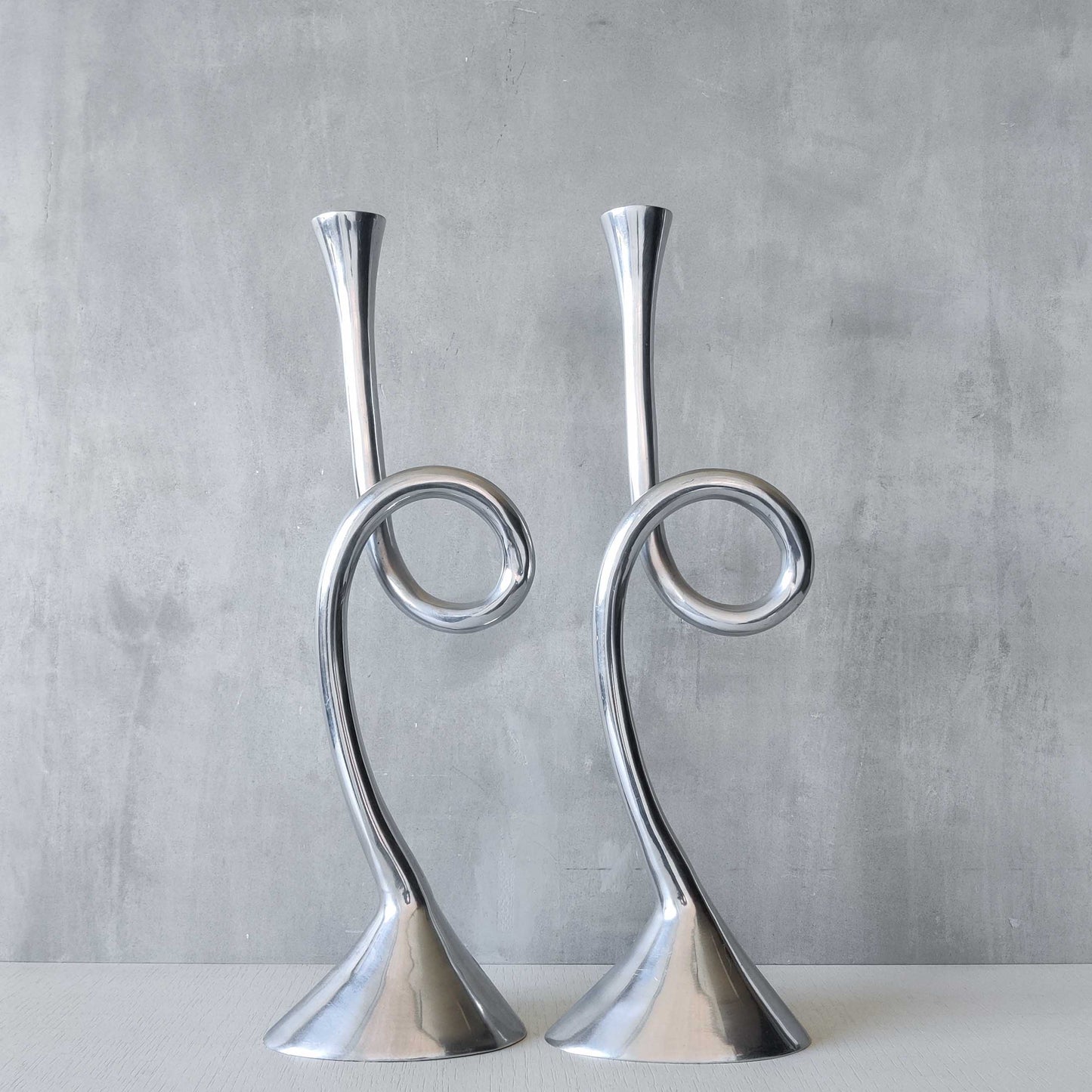 A pair of large vintage cast aluminium knotted loop candle holders