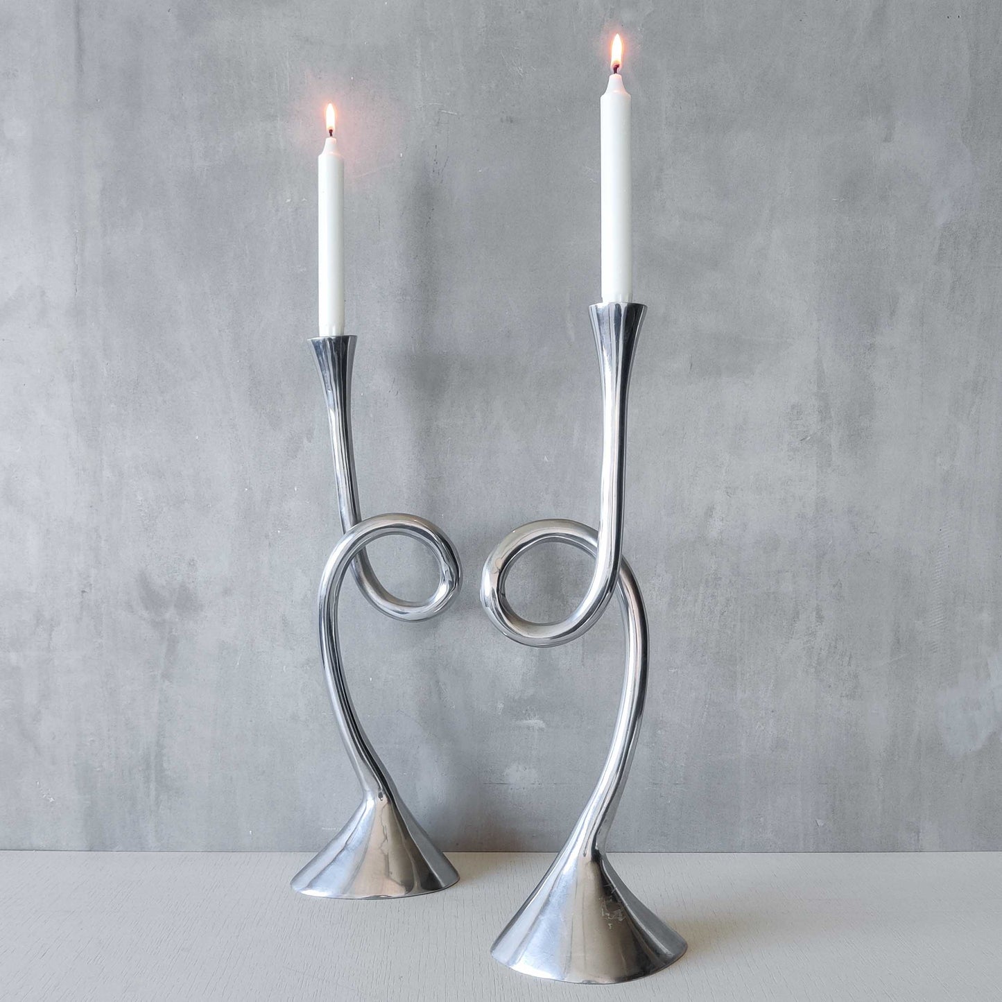 A pair of large vintage cast aluminium knotted loop candle holders