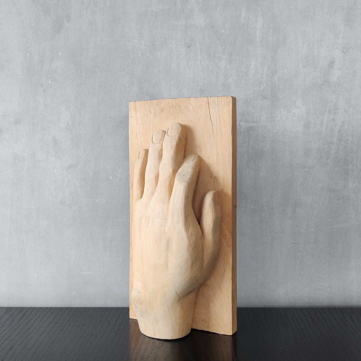 A carved tulip wood hand wall relief sculpture