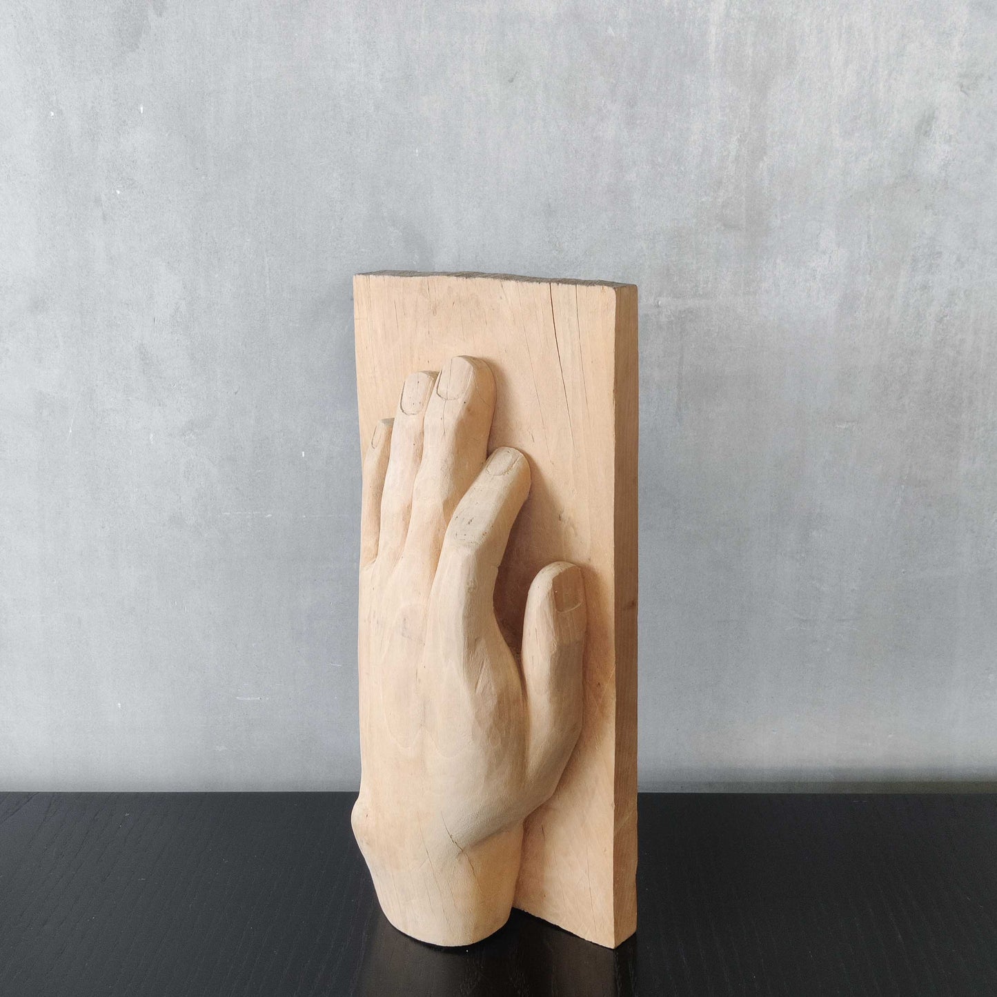 A carved tulip wood hand wall relief sculpture