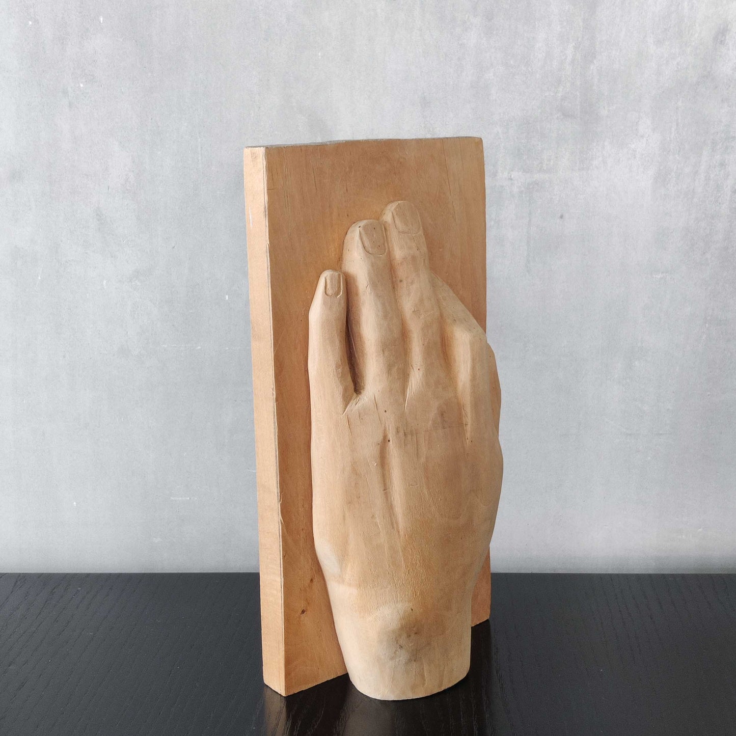 A carved tulip wood hand wall relief sculpture