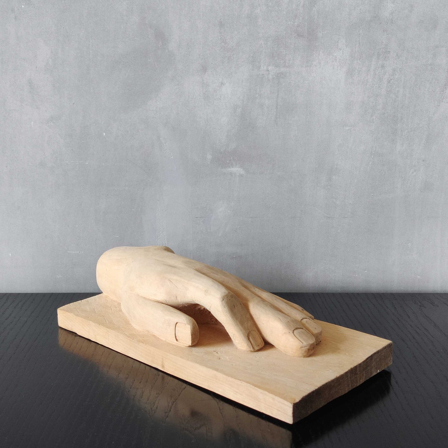 A carved tulip wood hand wall relief sculpture