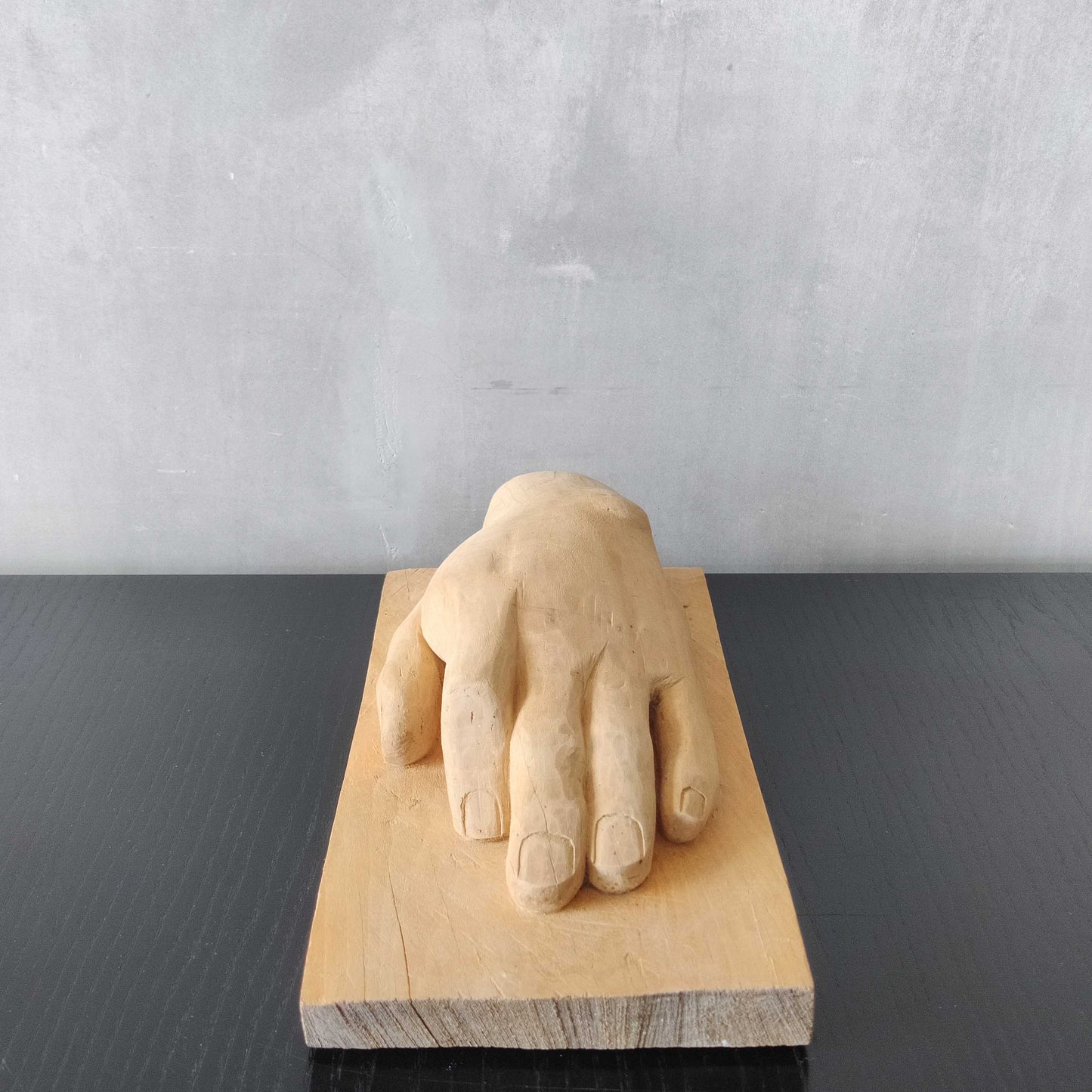 A carved tulip wood hand wall relief sculpture